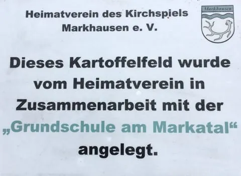 Schild mit dem Hinweis, dass der Heimatverein das Kartoffelfeld gemeinsam mit der Grundschule am Markatal angelegt hat