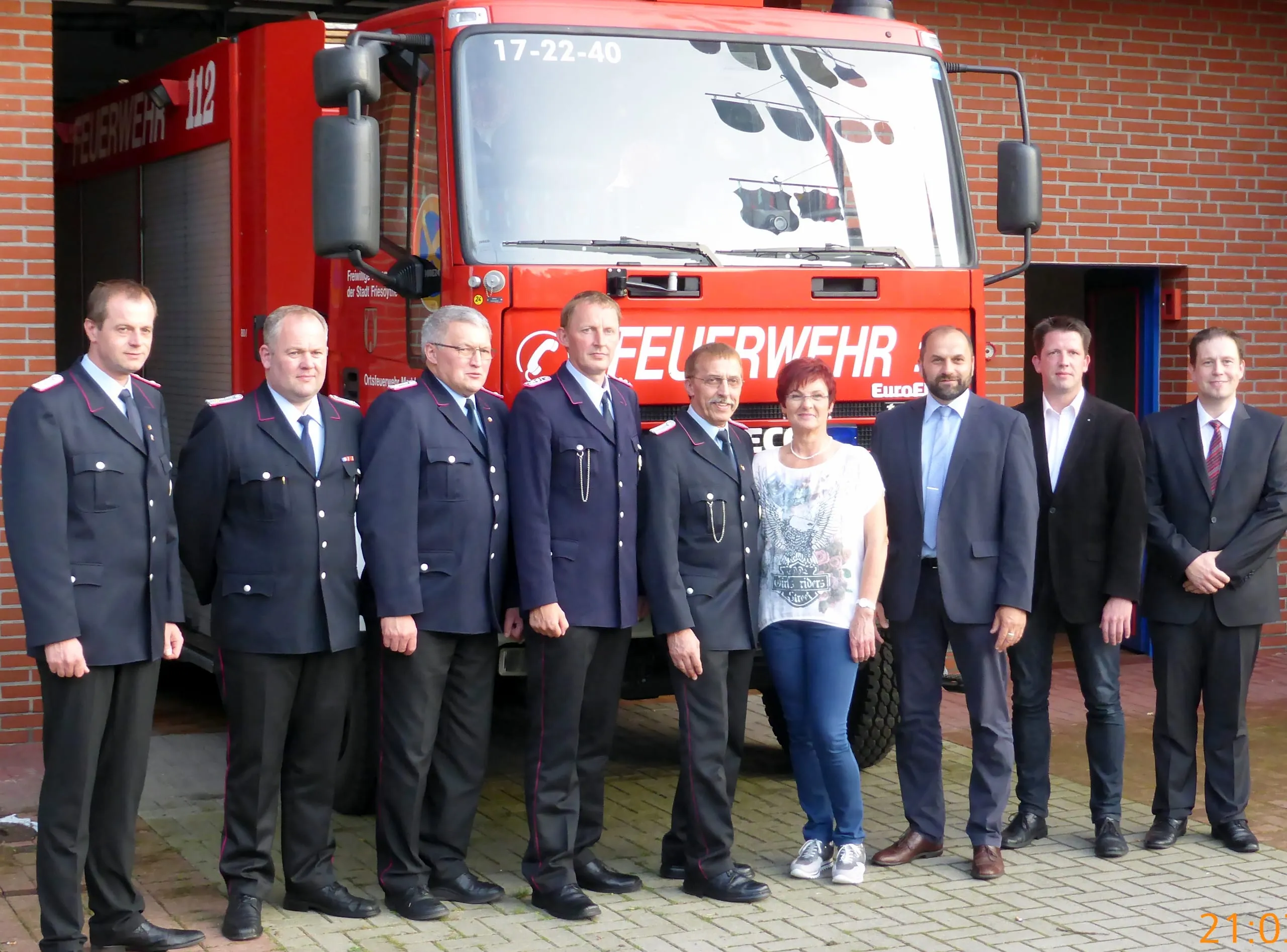 Feuerwehrleute in Uniform und Gäste vor dem Löschfahrzeug