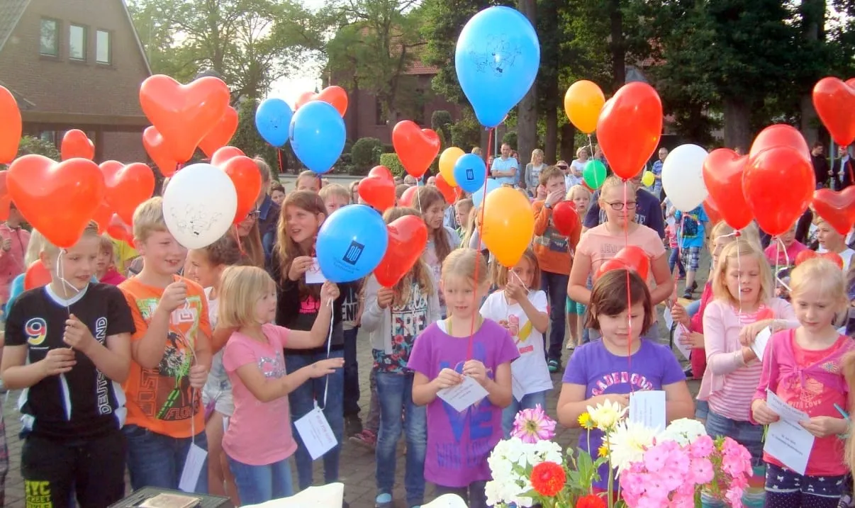 Kinder mit Luftballons und Wettbewerbskarten vor dem Start