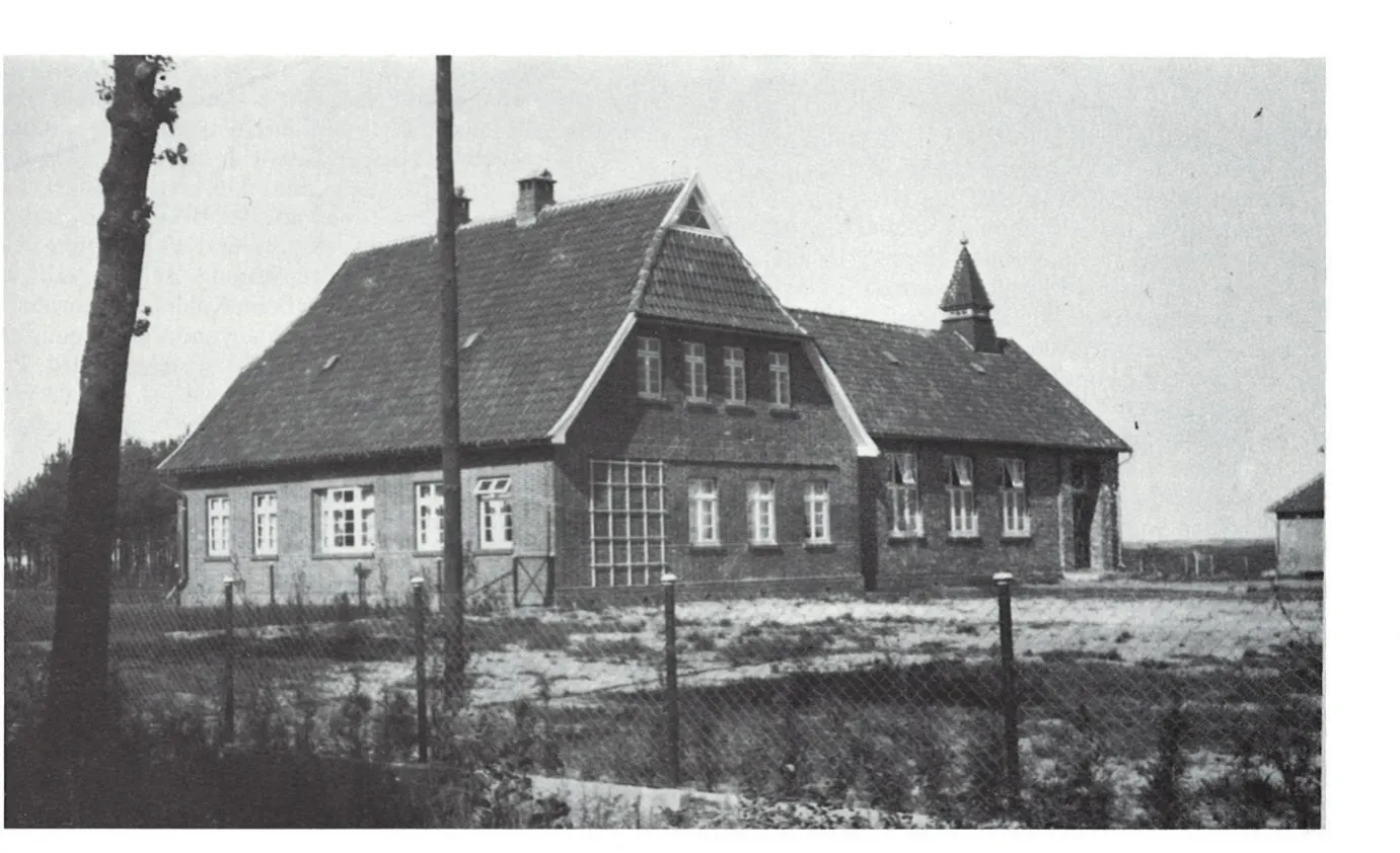 Schule mit Lehrerwohnung im Jahr 1927: zweiflügeliger Backsteinbau, davor ein frisch angelegter Zaun.