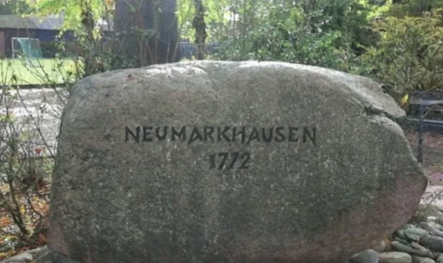 Großer Findling mit der eingemeißelten Inschrift ‚Neumarkhausen 1772‘.