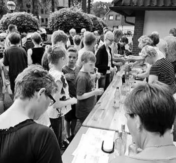 Besucherinnen und Besucher an einer langen Theke mit Getränken