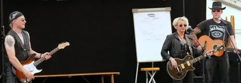 Dreiköpfige Band mit Gitarren auf der Bühne