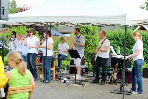 Band und Sängerinnen unter einem Pavillon beim Gottesdienst im Freien